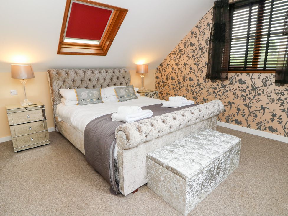 A bedroom with a bed and nightstands at Tynewydd Fields in Cross Inn