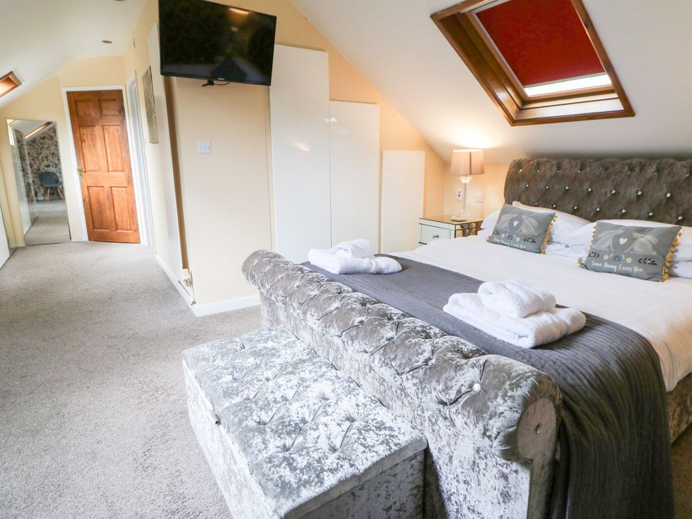 A bedroom with a bed and television at Tynewydd Fields in Cross Inn