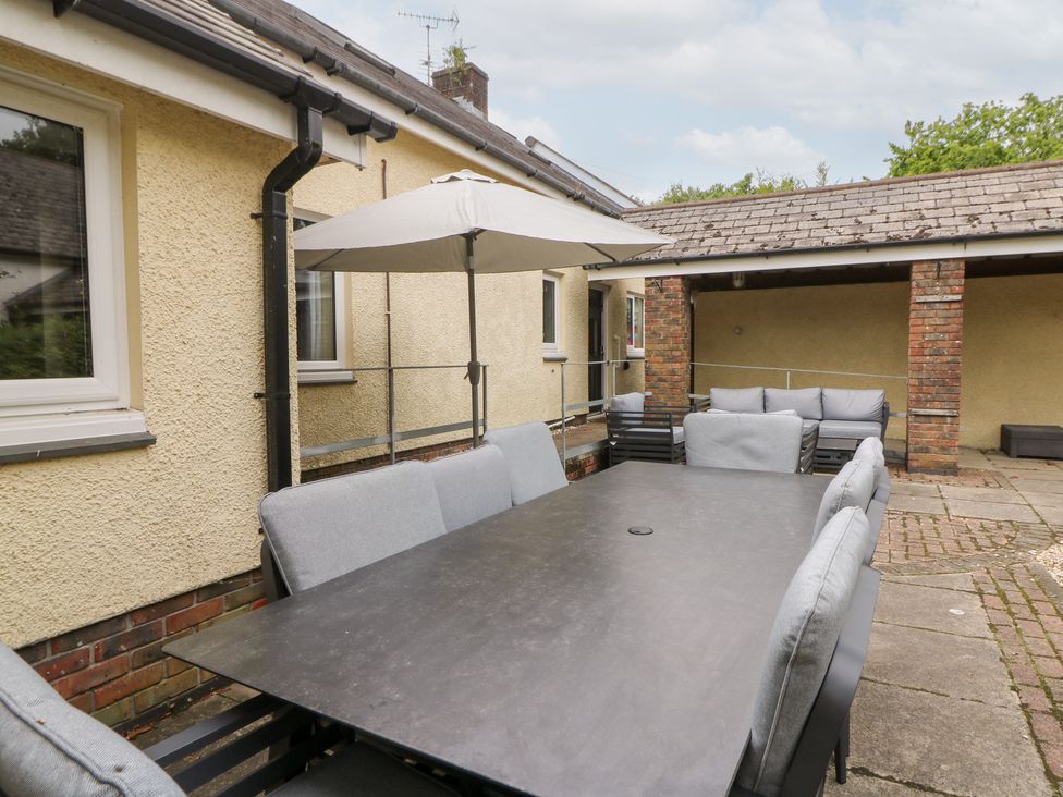 An outdoor dining area with a table and chairs at Tynewydd Fields in Cross Inn