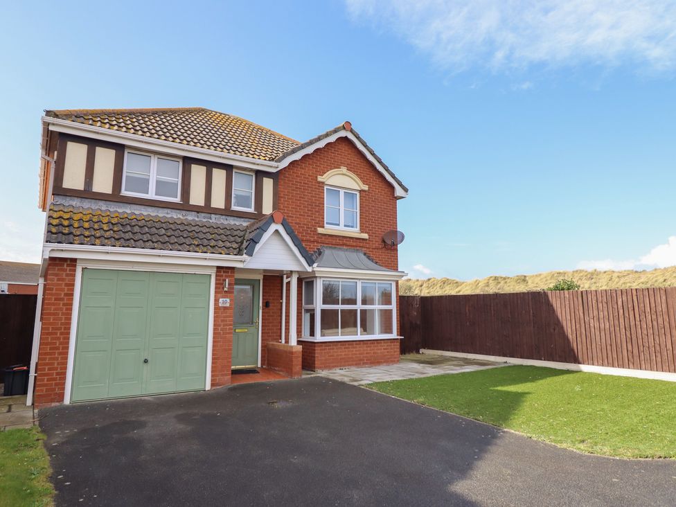 A house with a garage and lawn at The Beach House in Prestatyn