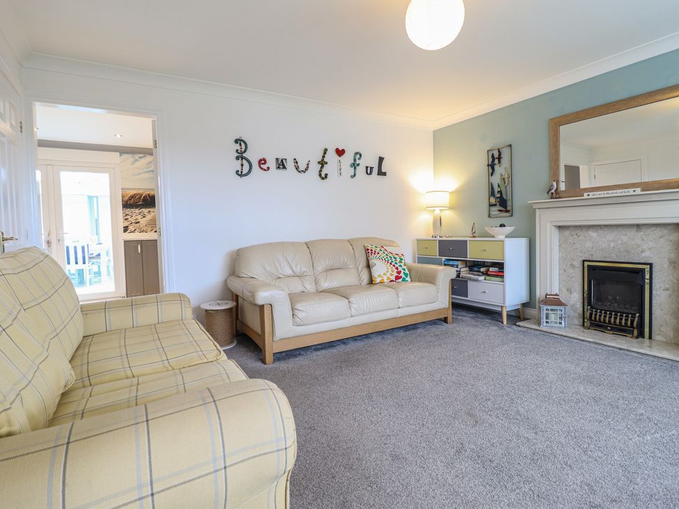 A living room with a sofa and fireplace at The Beach House in Prestatyn
