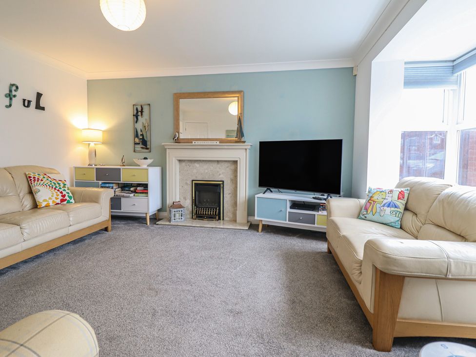 A living room with a television and a fireplace at The Beach House in Prestatyn