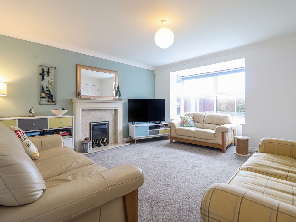 A living room with a television and fireplace at The Beach House in Prestatyn