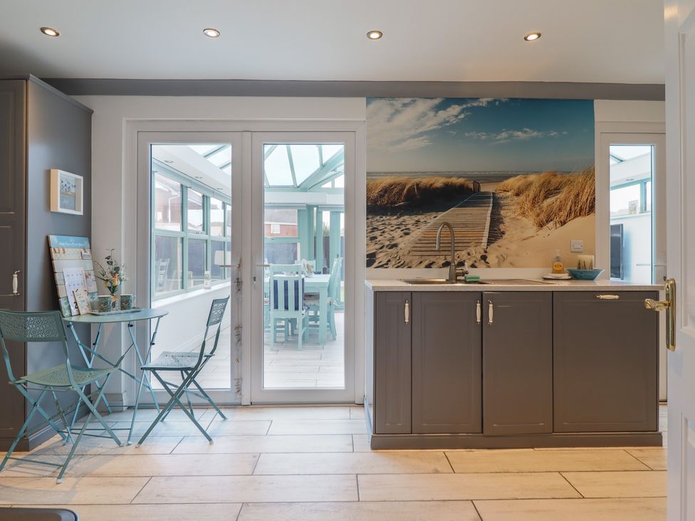 A kitchen with a sink and table in The Beach House in Prestatyn
