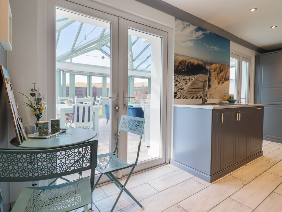 A kitchen with table and chairs at The Beach House in Prestatyn