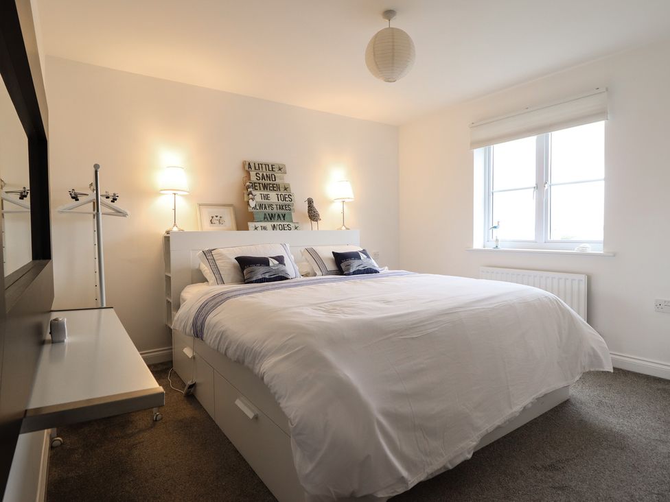 A bedroom with a bed and lamps at The Beach House in Prestatyn
