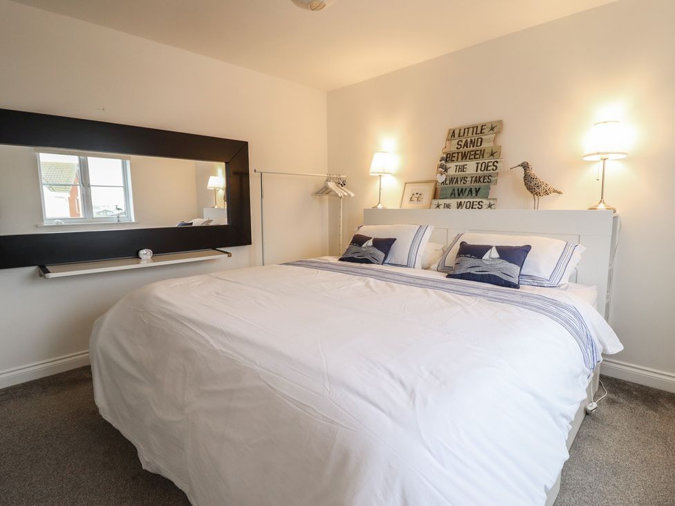 A bedroom with a bed and bedside lamps at The Beach House in Prestatyn