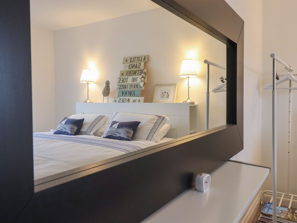 A bedroom with a bed and lamp at The Beach House in Prestatyn