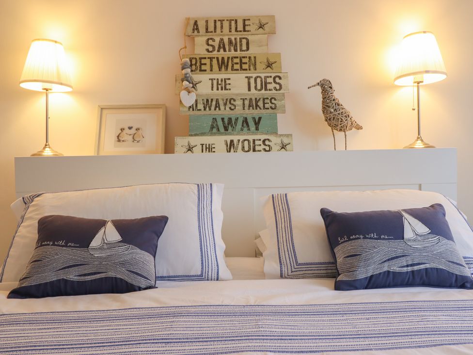 A bedroom with a bed and decorative items at The Beach House in Prestatyn