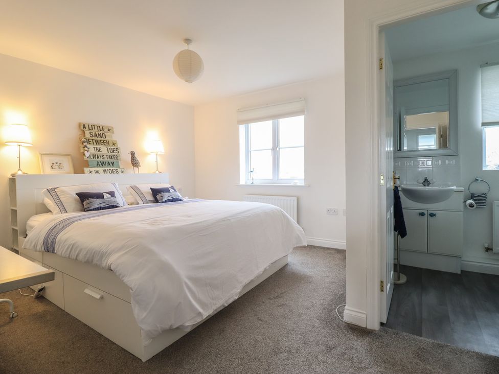 A bedroom with a bed and an attached bathroom at The Beach House in Prestatyn