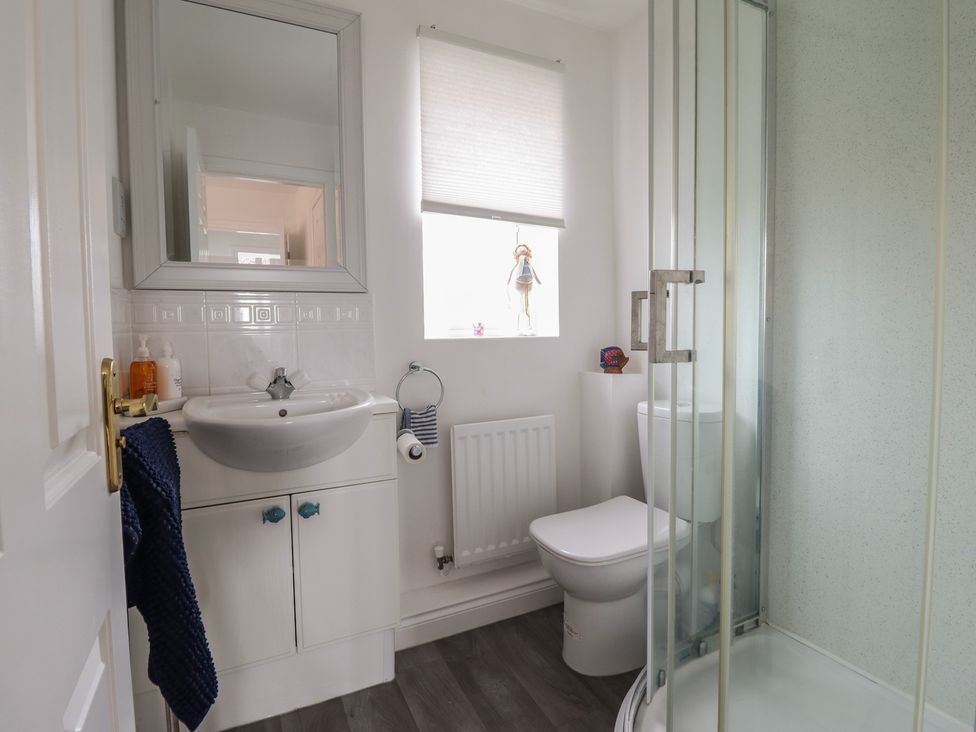 A bathroom with a sink, toilet, and shower at The Beach House in Prestatyn