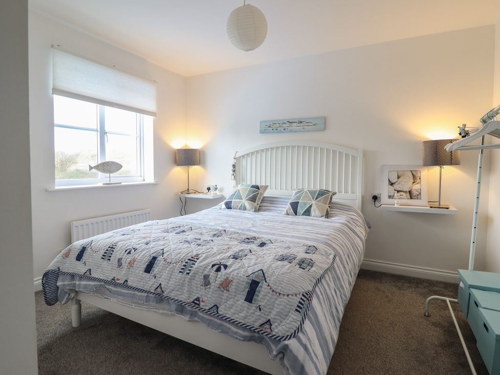 A bedroom with a bed and shelving at The Beach House in Prestatyn