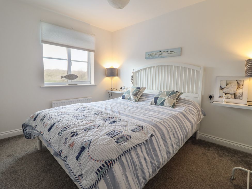 A bedroom with a bed and lamps at The Beach House in Prestatyn