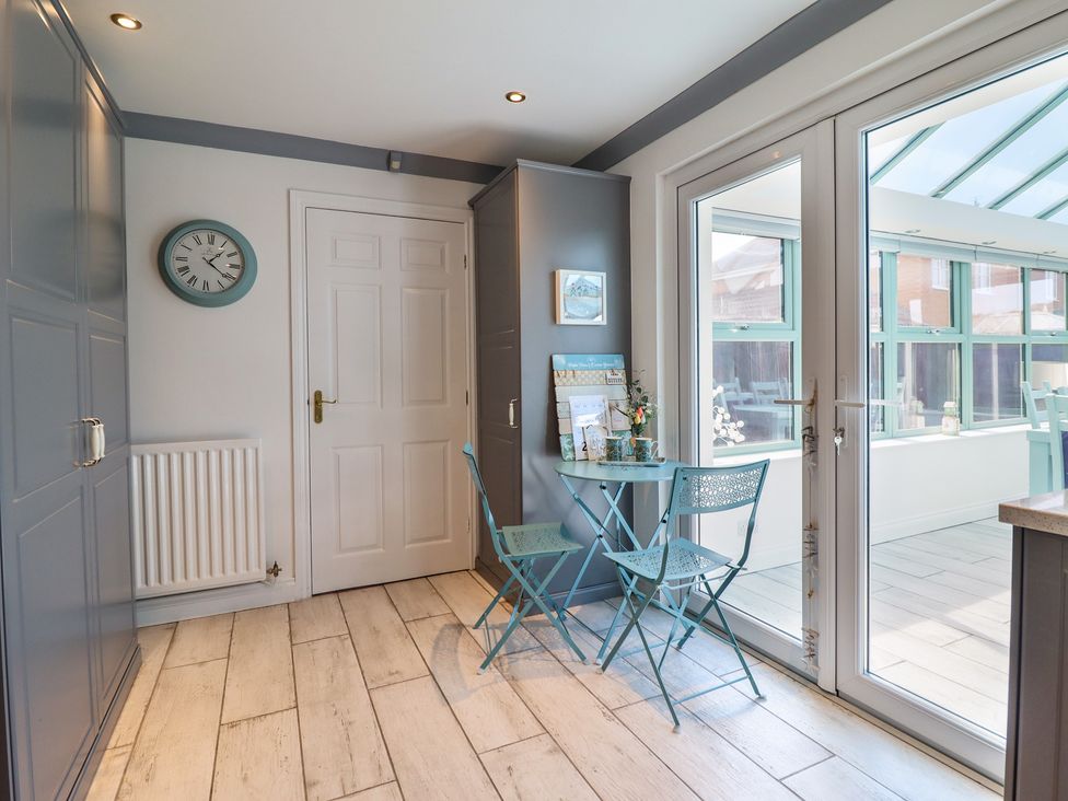 A kitchen with a table and chairs at The Beach House in Prestatyn