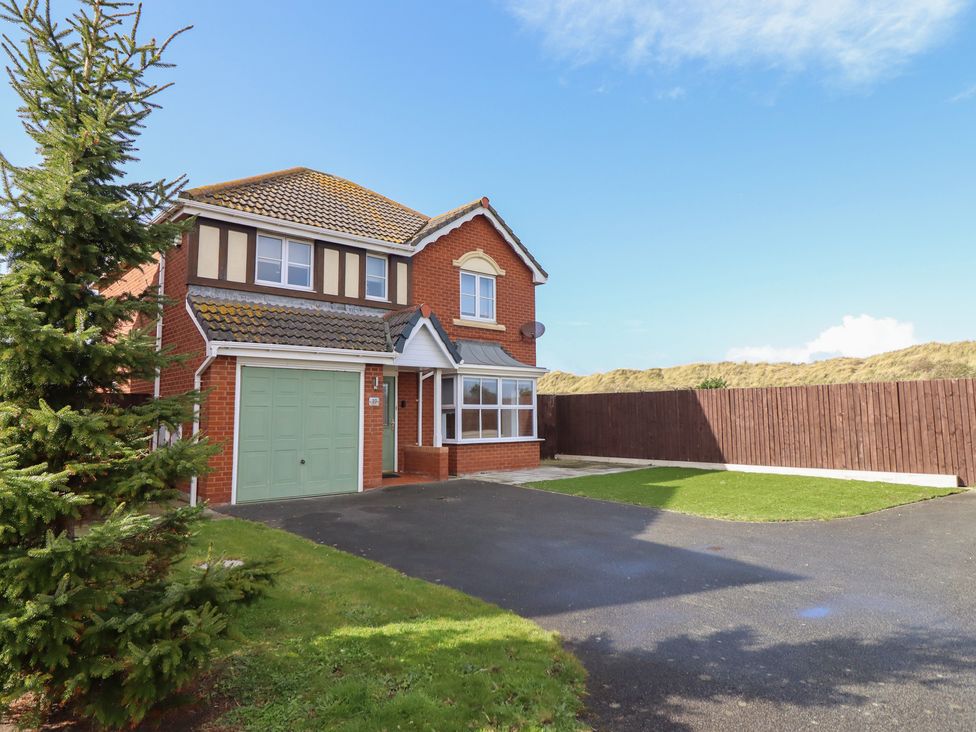 A house with a garage and lawn at The Beach House in Prestatyn
