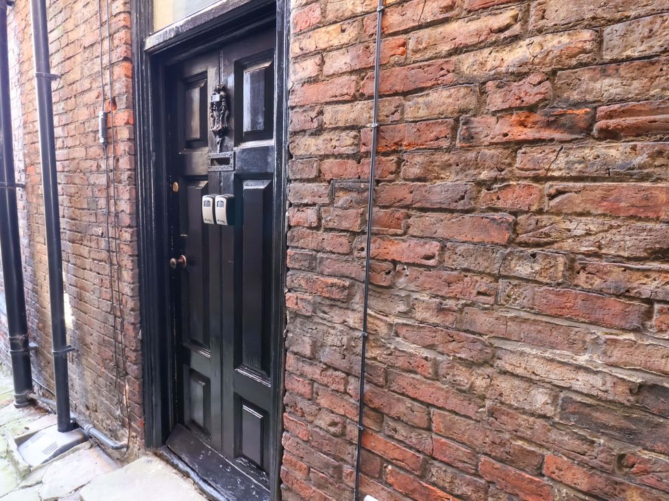 A door and brick wall with pipes outside at The Anchorage in Whitby