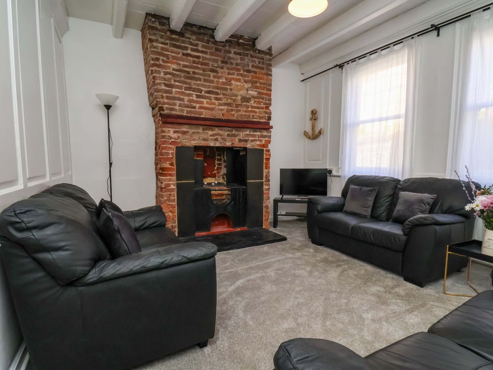 A living room with a fireplace and television at The Anchorage in Whitby