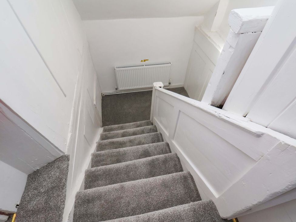 A staircase with carpet and a radiator at The Anchorage in Whitby