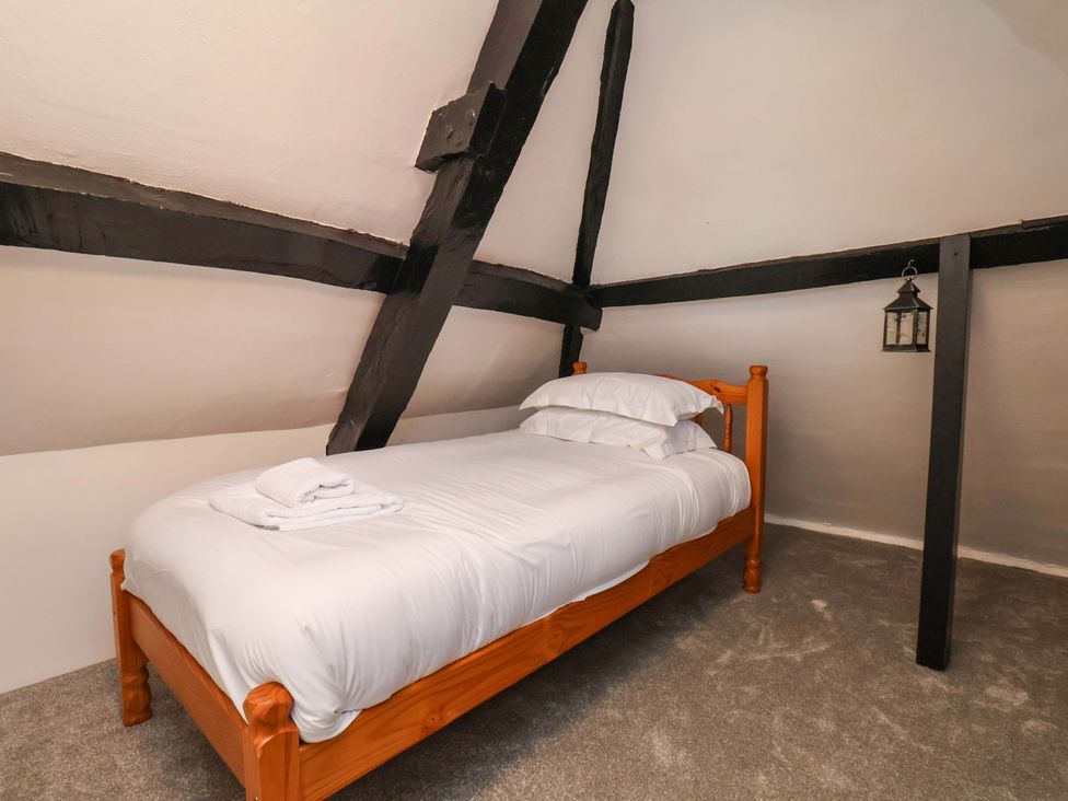 A bedroom with a wooden bed and lantern at The Anchorage in Whitby