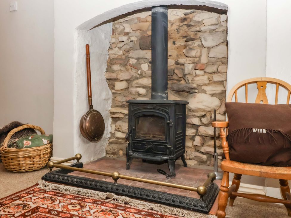 A living room featuring a stove and stone wall at Dunning, The Mount, York