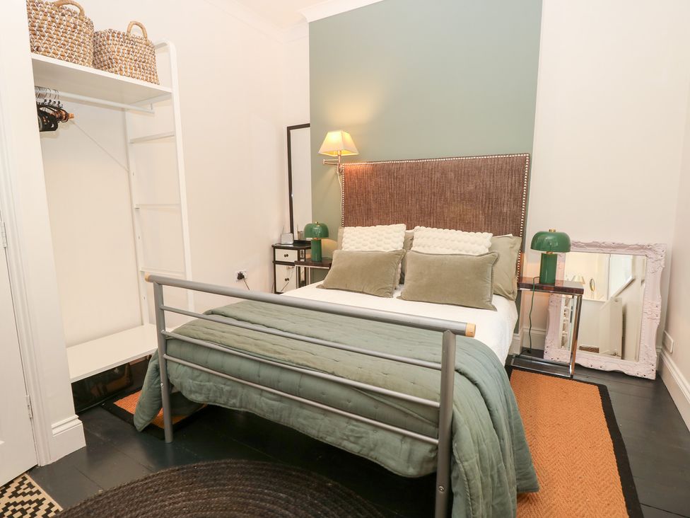 A bedroom with a bed and storage shelves at No. 5 Cliffview, Ventnor