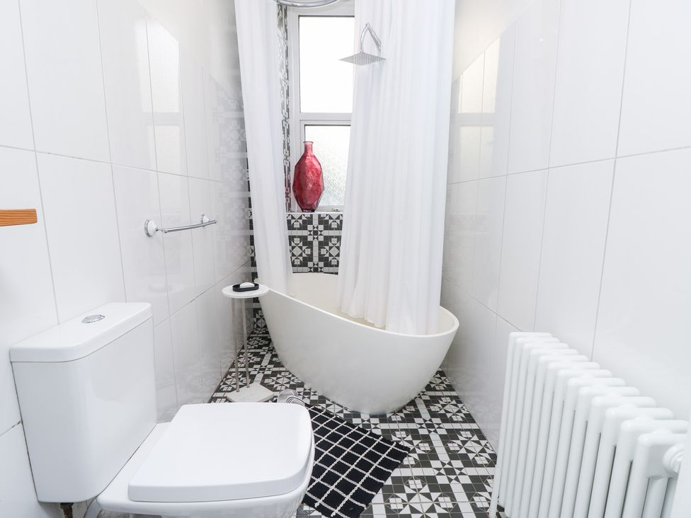 A bathroom with a bathtub and toilet at No. 5 Cliffview in Ventnor