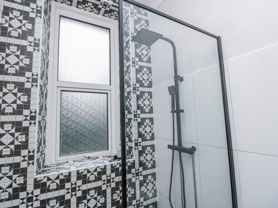 A shower with tiles and a window at No. 5 Cliffview in Ventnor