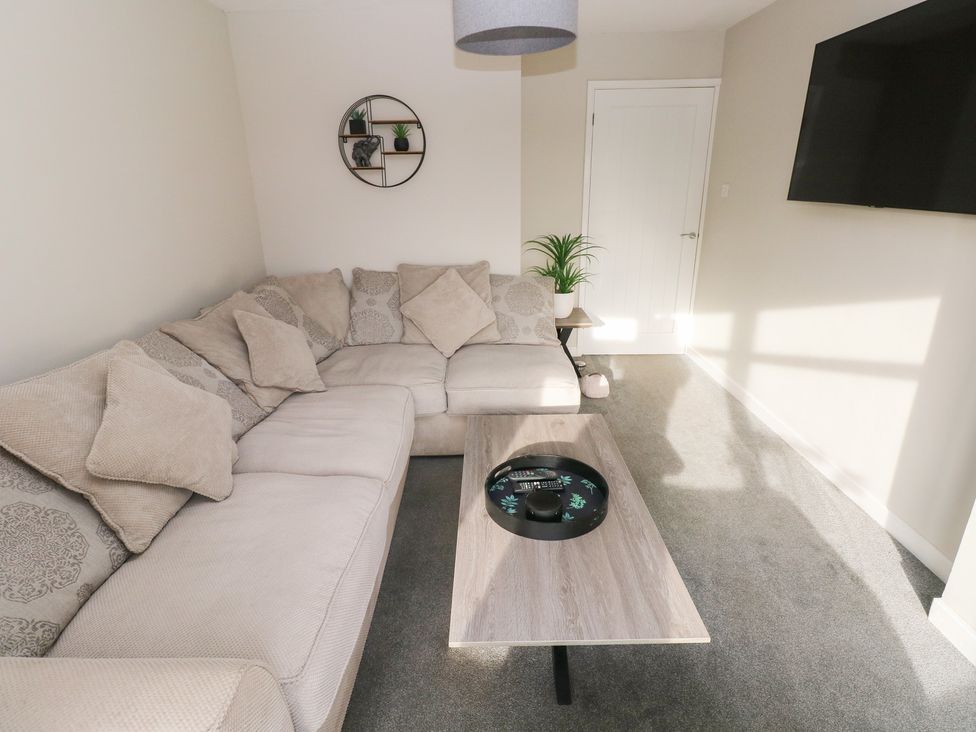 A living room with a sofa and coffee table at Westwinds in Tenby
