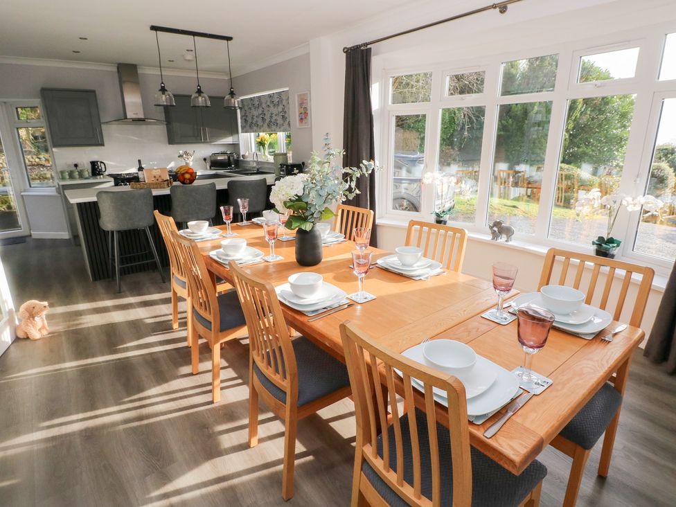 A dining room with a table set for dinner at Westwinds in Tenby
