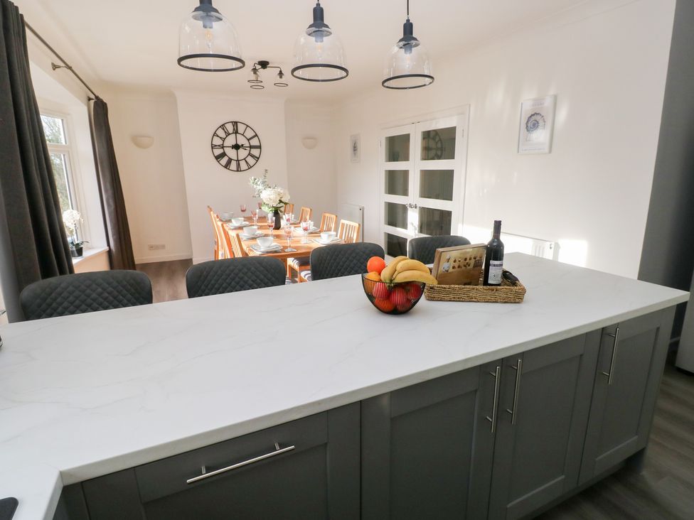 A dining area with a table set for a meal at Westwinds in Tenby