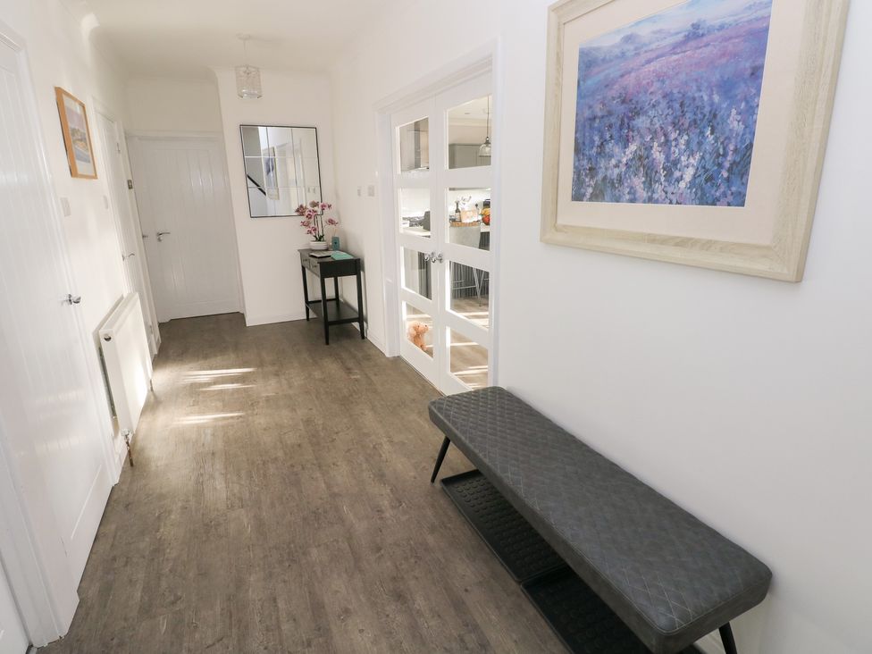 A hallway with a bench and table at Westwinds in Tenby