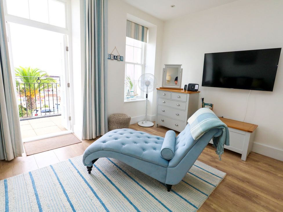 A living room with a chaise lounge and television at 4 The Beaches in Weymouth