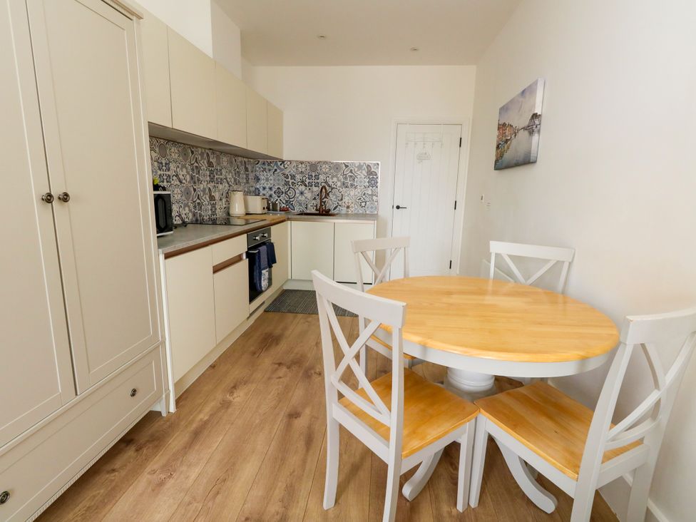 A kitchen with a table and chairs at 4 The Beaches in Weymouth