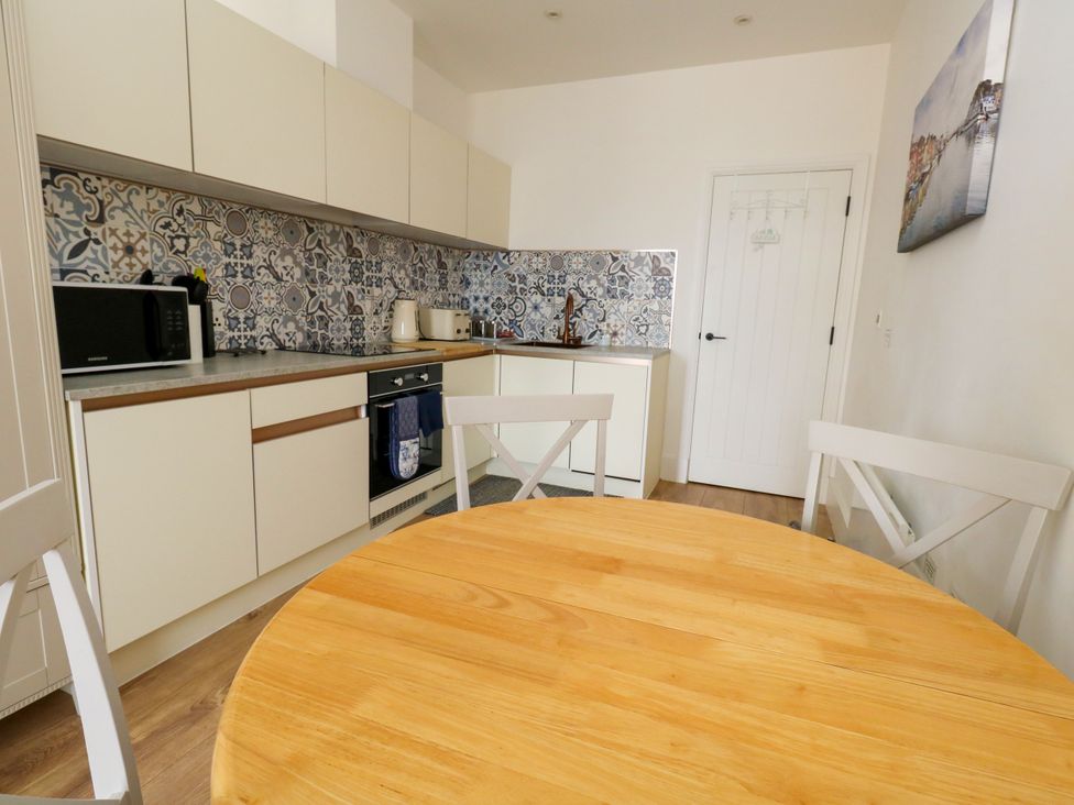 A kitchen with a table and appliances at 4 The Beaches in Weymouth