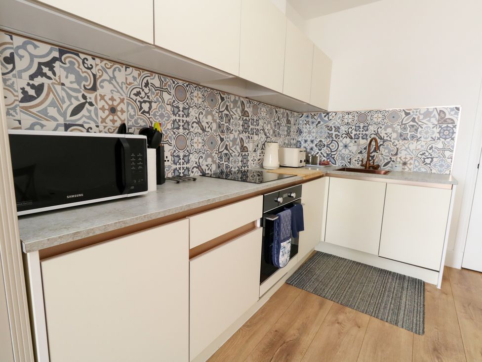 A kitchen with microwave and sink at 4 The Beaches in Weymouth