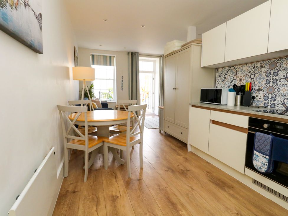 A kitchen with a dining area and appliances at 4 The Beaches in Weymouth