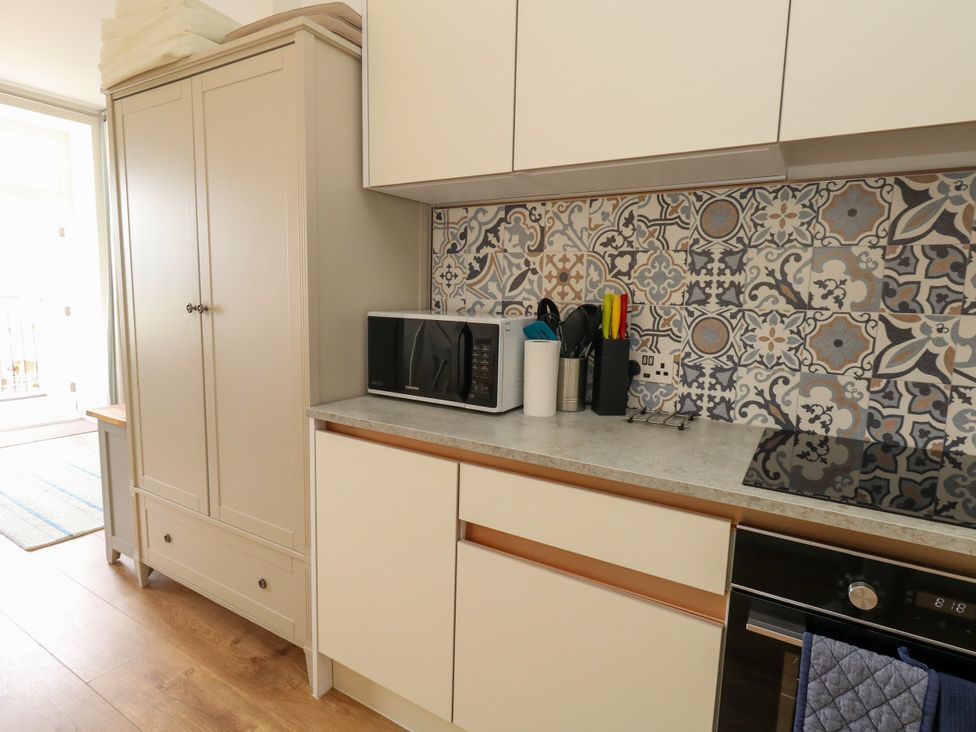 A kitchen with a microwave and utensils at 4 The Beaches Weymouth