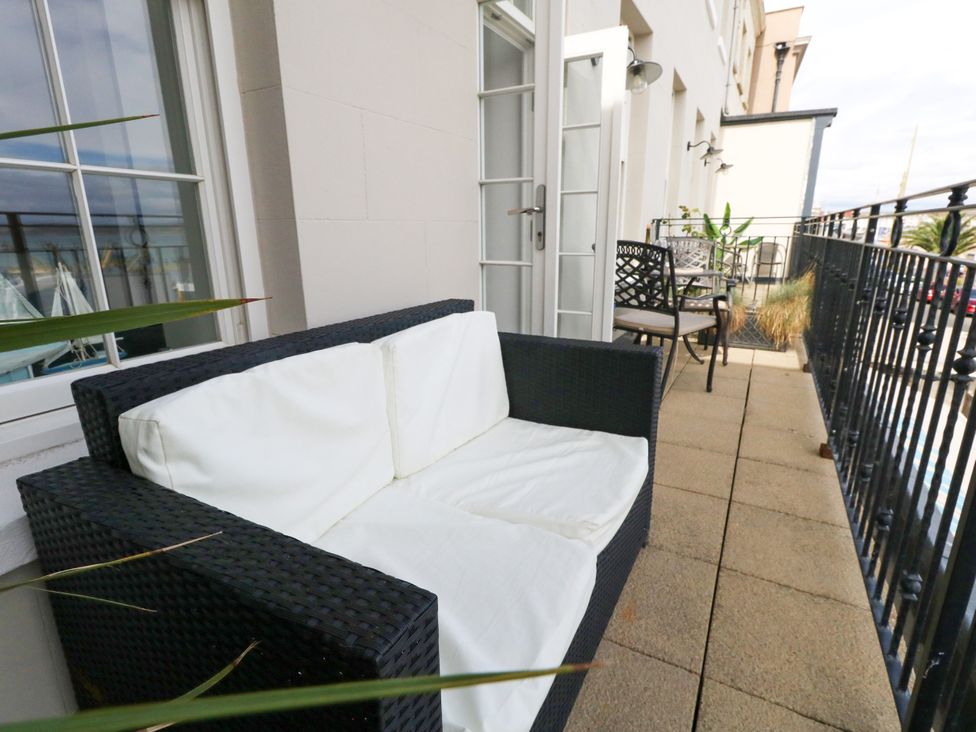 A balcony with a couch and table at 4 The Beaches in Weymouth