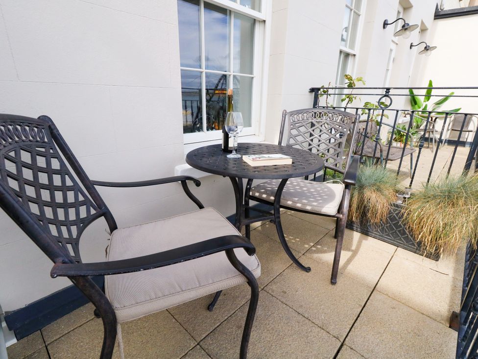 A balcony with two chairs and a table at 4 The Beaches in Weymouth