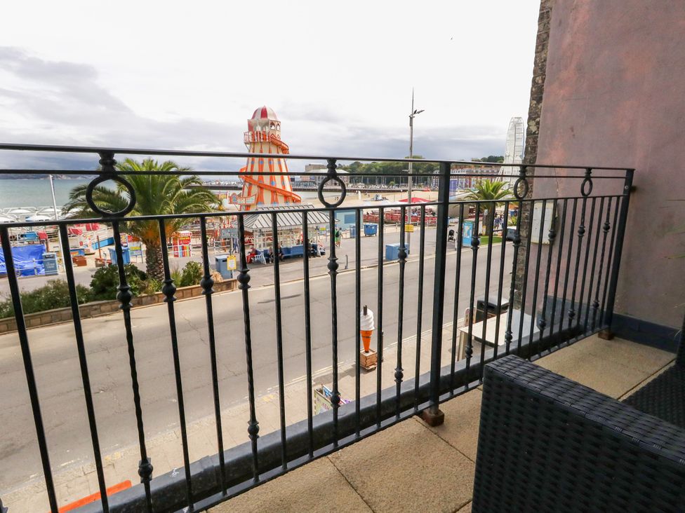 A balcony view overlooking a road and beach at 4 The Beaches in Weymouth