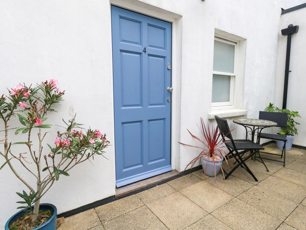 An outdoor area with a blue door and seating at 4 The Beaches in Weymouth