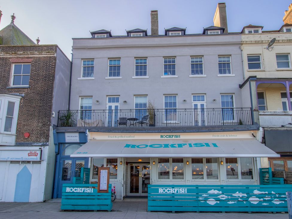 A restaurant building with a balcony and sign at 4 The Beaches in Weymouth