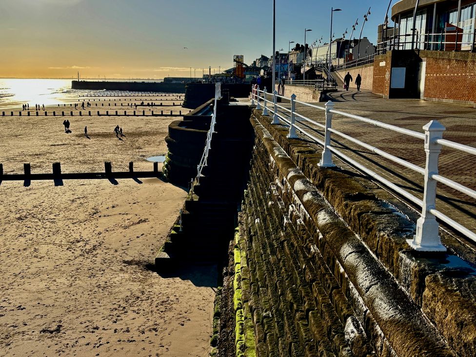A beach view with people walking along the sand at Bobbies' Retreat, 20 High Street, Bridlington