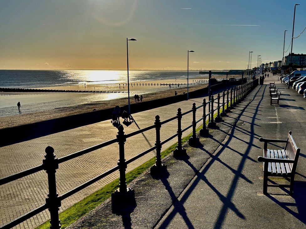 A beach promenade with benches and people walking at Bobbies Retreat, 20 High Street Bridlington