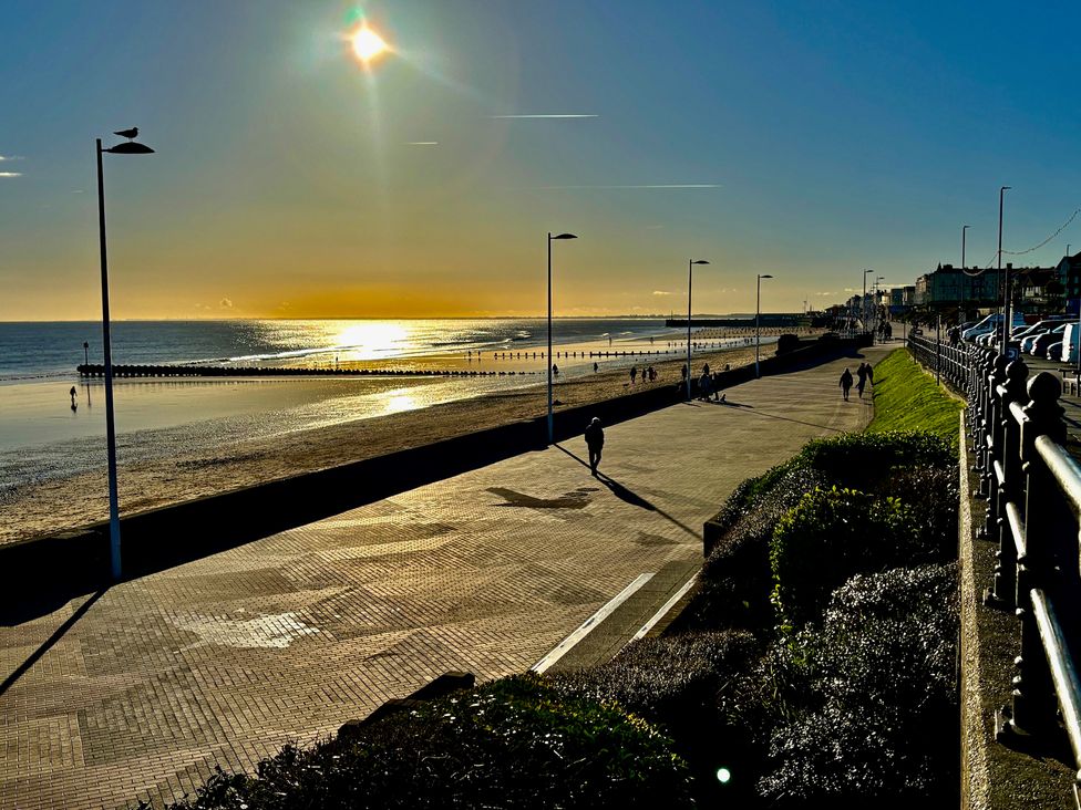 A beach view with sunset and people walking at Bobbies' Retreat, 20 High Street Bridlington