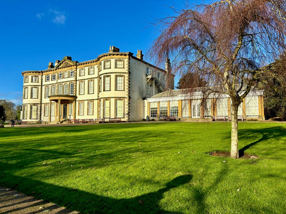 A building with a glasshouse and benches in a garden at Bobbies' Retreat, 20 High Street, Bridlington