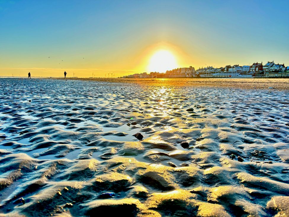 A beach during sunset with people walking at Bobbies' Retreat, 20 High Street Bridlington