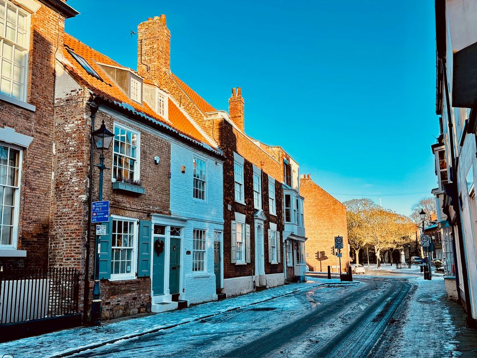 A street scene with historic buildings and road signs at Bobbies Retreat, 20 High Street Bridlington