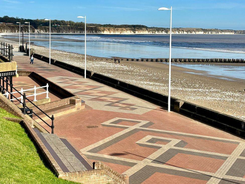 A beach promenade with lamp posts and a view of the sea and cliffs at Bobbies Retreat, 20 High Street, Bridlington