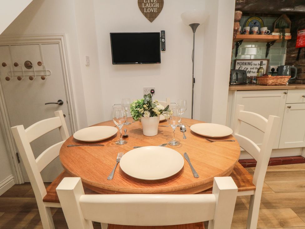 A dining room with a round table and chairs at Bobbies' Retreat, 20 High Street Bridlington